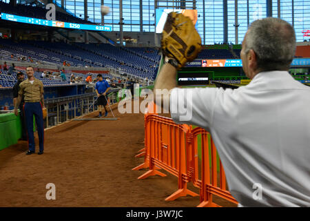 MIAMI, Florida - Staff Sgt. Jeremy R. Plympton, hilft links, Hinterer Admiral Roy I. Kitchener wärmen Sie sich vor die Marlins versus Strahlen Baseballspiel im Marlins Stadium 2. Mai 2017. Kitchener, der Kommandant der Expeditionary Strike Group 2, warf den Ball Spiel Öffnung im Rahmen der 27. Flotte Woche Port Everglades. Plympton, eines mehr als 100 II Marine Expeditionary Force Marines Flotte Woche Teilnahme ist der Waffen-Zug-Sergeant für Ostindien-Kompanie, 3. Bataillon, 2. Marine Regiment. (United States Marine Corps Foto von Staff Sgt. Rebekka S. Heite/freigegeben) Stockfoto