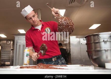 Am 3. Mai 2017 bereiten Mitarbeiter an Bord der USS America in der Bäckerei des Schiffes Essen zu, während die America Amphibious Ready Group und die 15th Marine Expeditionary Unit vor Südkalifornien eine Composite Training Unit Übung durchführen, um den Einsatz vorzubereiten. Stockfoto