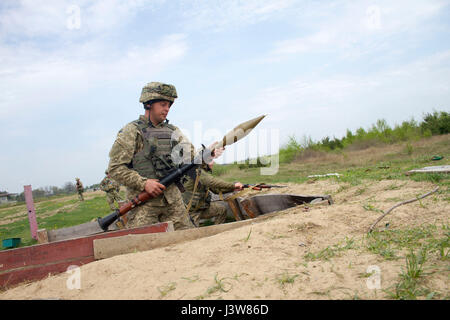 Ukrainische Soldat der 1. Airmobile Bataillon zugeordnet, 79. Air Assualt Brigade lädt seine RPG-7 vor dem Brand während RPG Qualifikation am Yavoriv Combat Training Center auf der internationalen Friedenssicherung und Sicherheit Training Center in der Nähe von Yavoriv, Ukraine, am 4. Mai.    CTC-Trainer, eine Partnerschaft mit Soldaten der US Army 45. Infantry Brigade Combat Team, sind Truppen von der ukrainischen Armee 1. Airmobile Bataillon, 79. Air Assault Brigade Lehren, während das Bataillon Drehung an der CTC RPGs beschäftigen. 45. IBCT wird als Bestandteil der gemeinsamen multinationalen Training Gr bereitgestellt. Stockfoto