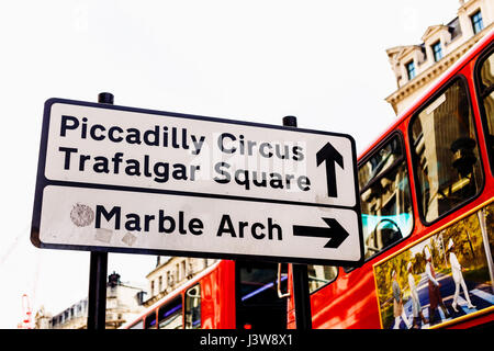 LONDON, UK - 11. August 2014: Straßenschild in London mit berühmten Sehenswürdigkeiten wie Piccailly und Trafalgar oder Marble Arch mit Doppeldecker Bus bokeh Stockfoto