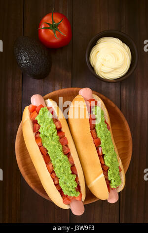 Chilenische Completo Italiano (italienische) traditionellen Hot-Dog-Sandwich, gemacht von Brot, Wurst, Tomaten und Avocado, Mayonnaise in Schälchen auf der Seite Stockfoto