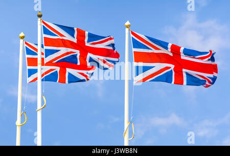 Union Jack-Flaggen des Vereinigten Königreich von Großbritannien und Nordirland, auf Stangen gegen blauen Himmel fliegen. Stockfoto