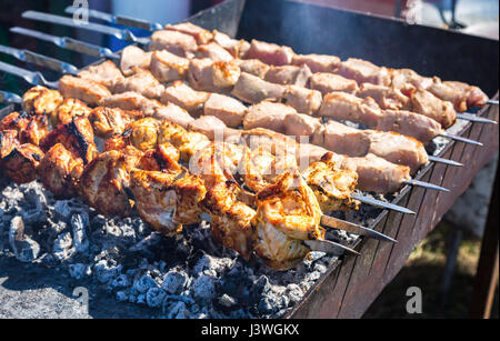 Saftige Scheiben von Fleisch mit Soße vorbereiten auf die heißen Kohlen Stockfoto