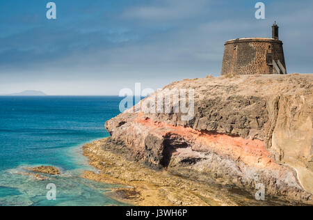 Castillo de Las Coloradas auf den Klippen östlich von Playa Blanca, Lanzarote, mit der Insel Fuerteventura in der Ferne Stockfoto