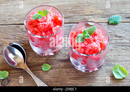 Erdbeer-Granita mit Minze (gefrorene Dessert) in Teil Gläser auf hölzernen Hintergrund Stockfoto