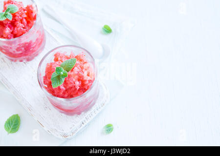 Erdbeer-Granita mit Minze (gefrorene Dessert) in Teil Gläser auf weißem Hintergrund mit Textfreiraum Stockfoto