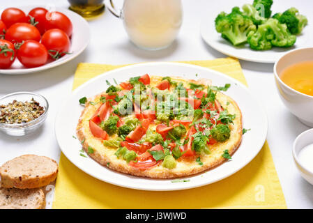 Frühstück mit Spiegeleiern. Omelette mit Gemüse auf Teller Stockfoto