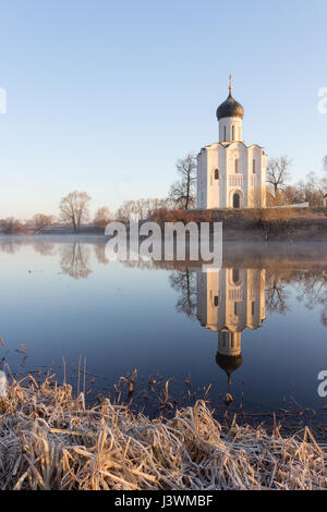 Einem nebligen See mit einem Boot vor der Kirche im frühen Frühling in der Morgendämmerung Stockfoto