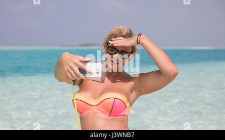 Hübsche Frau macht selfie am Strand Stockfoto