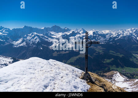 Auf dem schneebedeckten Gipfel des Rossstock (2461m) überqueren. Im Hintergrund Panorama der vielen Gipfeln der Schweizer Alpen. Kanton Uri, Schweiz. Stockfoto