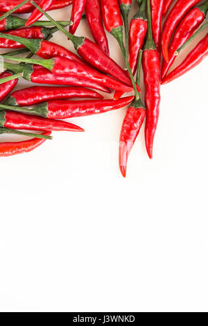Rot-heiße Paprika, beliebte Gewürze Konzept - Streuung von red hot Chili peppers, isoliert auf weißem Hintergrund, Ansicht von oben, flach liegen, viel Freiraum für Ihren Text. Stockfoto