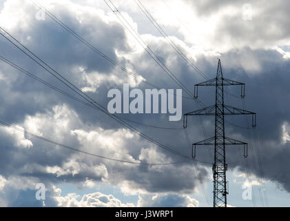 Pylon mit Hochspannungs-Leitungen und Gewitterwolken Stockfoto