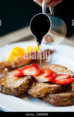 Essen, Mahlzeiten Frühstück Französisch Toast mit Strawberrie und Sirup drüber gegossen wird Stockfoto