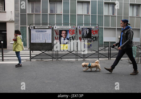 Paris, Frankreich. 7. Mai 2017. Menschen zu Fuß durch Wahlplakate der französischen Präsidentschaftskandidaten Emmanuel Macron En Marche! Bewegung im 18. Arrondissement von Paris als französischen Wähler gehen zu den Urnen zu stimmen in der zweiten Runde der französischen Präsidentenwahl am 7. Mai 2017 in Paris, Frankreich. Bildnachweis: VWPics/Alamy Live-Nachrichten Stockfoto