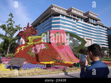 Peking, China. 7. Mai 2017. Ein Mann nimmt Fotos von Blumendekorationen setzen auf die kommende Gürtel und Road-Forum für internationale Zusammenarbeit an einer Kreuzung in der Nähe von Xidan Geschäftsviertel im Zentrum von Peking, die Hauptstadt von China, 7. Mai 2017 zu begrüßen. Beijing wird der Gürtel und Road-Forum für internationale Zusammenarbeit am 14.-15. Mai veranstaltet. Bildnachweis: Chen Xiaogen/Xinhua/Alamy Live-Nachrichten Stockfoto