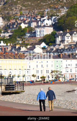 Conwy County, Wales, UK. Wetter, herrlichen Sonnenschein an der britischen Westküste heute einschließlich North Wales. - Ein paar Hände halten und entlang der Promenade an der beliebten North Wales Küstenstadt Llandudno Spaziergang Stockfoto