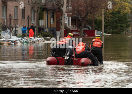 Montreal, Kanada. 8. Mai 2017. Feuerwehr ein aufblasbares Boot verwenden, um Bewohner als Überschwemmungen Hits Cousineau Straße Credit: Marc Bruxelle/Alamy Live News Stockfoto