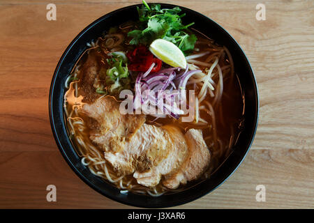 Eine Schüssel mit Chili Chicken Nudeln mit frisch gehackten Gemüse serviert. Ramen-Nudeln ist ein beliebtes asiatischen Gericht. Stockfoto