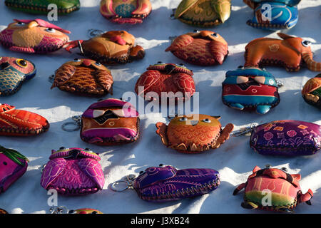 Farbenfrohe Lederhandtaschen auf einem Bürgersteig in einem Straßenmarkt in Porto, Portugal Stockfoto