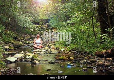 Meditation im tiefen Wald an Creek Seite Stockfoto