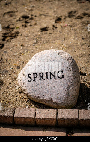 Wort Feder geschrieben, Frühling Gravur, Prägung, auf einem dekorativen Garten Stein, Jahreszeiten des Jahres, Dekoration, Gartenstein, dekorativen Stein Zeichen. Stockfoto