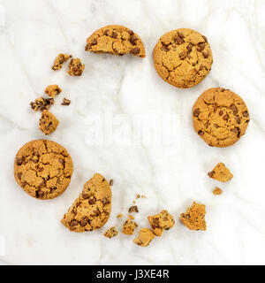 Ein quadratischer Foto eines Rahmens bestehend aus Schokolade-Chips Cookies und Krümel, geschossen von oben auf weißem Marmor Hintergrund, mit einem Platz für text Stockfoto