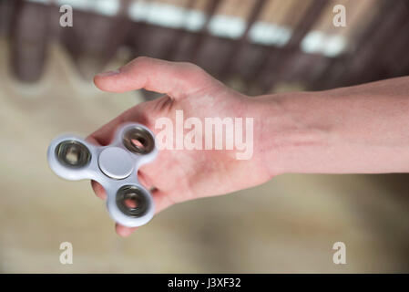 Kleiner Junge spielt mit Fidget Spinner Spielzeug um Stress zu Hause Stockfoto