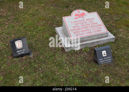 Massengrab von 1.584 Rotarmisten gefallenen Soldaten während des zweiten Weltkriegs auf dem Boden das Sowjetische Ehrenmal auf dem Zentralfriedhof in Brünn, Tschechien. Fotografien von sowjetischen Offizieren Abram Shapiro (L) und Ivan Lyubchenko (R) wurden nach dem Krieg durch die Verwandten installiert. Unterleutnant Abram Shapiro wurde im Jahr 1911, diente in der Roten Armee während des zweiten Weltkriegs und starb von Wunden im Alter von etwa 34 am 25. April 1945 in Brünn in Südmähren, Tschechoslowakei geboren. Junior Sergeant Ivan Lyubchenko wurde am 21. Juni 1907 geboren und starb im Alter von 38 Jahren am 23. September 1945 an unbekannten Krankheit. Stockfoto