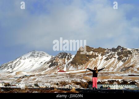 Eine Frau Arme gestreckt genießt das Panorama in Vic Iceland