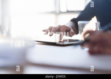 Mit digitalen Tablet-PC auf dem Schreibtisch Mann, Nahaufnahme einer Hand, Stockfoto