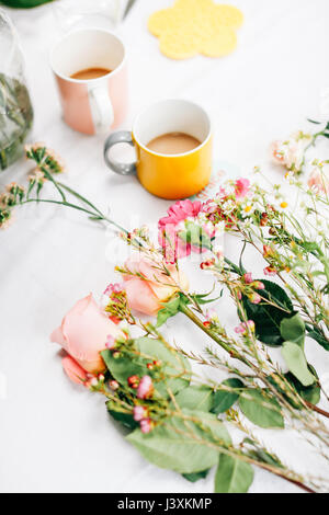 Tabelle mit Blumen und Kaffee Tassen blumenarrangierens Workshop Stockfoto