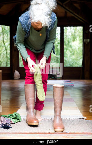 Frau, die Socken und Schuhe anziehen Stockfoto