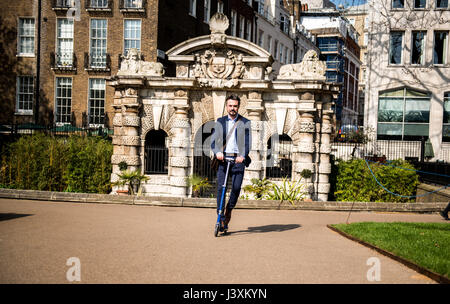 Geschäftsmann auf Roller, London, UK Stockfoto