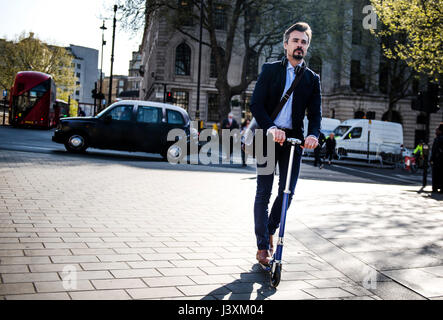 Geschäftsmann auf Roller, London, UK Stockfoto