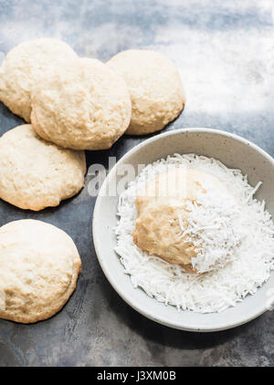 Kekse und Schüssel mit Kokosraspeln Stockfoto