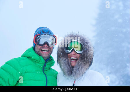 Portrait von Happy reifes Paar im fallenden Schnee, Gstaad, Schweiz Stockfoto