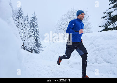 Männliche Läufer, die auf Spur in den tiefen Schnee, Gstaad, Schweiz Stockfoto