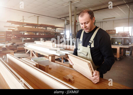 Männliche Tischler Inspektion Laufbelag an Workbench Stockfoto