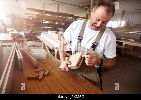 Männliche Tischler einfügen Holzdübel in Workbench Stockfoto