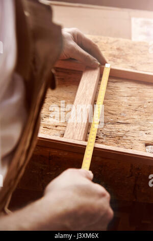 Die Hände der männlichen Tischler Messrahmen an Workbench Stockfoto