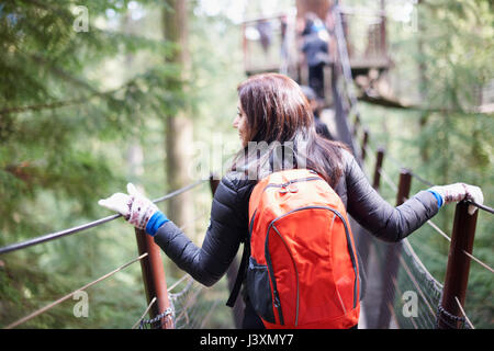 Frau gehen über Capilano Suspension Bridge, Rückansicht, Vancouver, Kanada Stockfoto