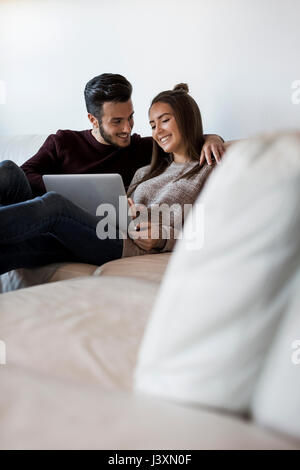 Junges Paar auf Sofa entspannen, mit Blick auf laptop Stockfoto