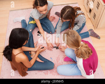 Mädchen sitzen auf Boden Domino spielen Stockfoto