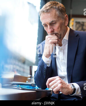 Reifen Geschäftsmann mit digitalen Tablet im Restaurant Fensterplatz Stockfoto