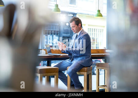 Reifen Geschäftsmann an Smartphone im Restaurant suchen Stockfoto