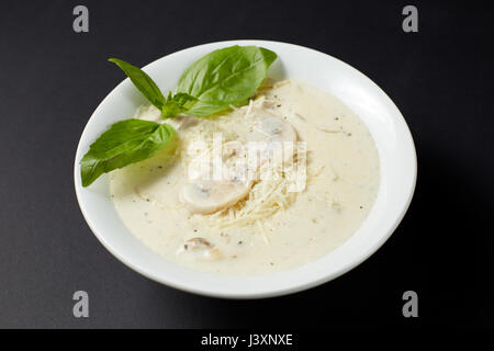 Creme-Suppe mit Hühnerfleisch und Champignons. Italienischen Stil. Italienisches Essen. Italienische Küche. Studio auf dunklen oder schwarzen Hintergrund gedreht. Stockfoto