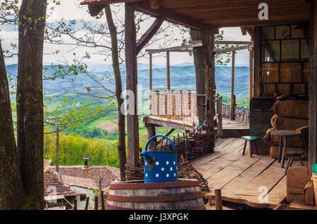 Teil eines alten serbischen Haushalt, Holzhaus und Terrasse und Natur im Frühjahr im Hintergrund. Stockfoto