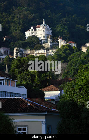 Dächer in Santa Teresa mit Tijuca-Wald & das Castelinho (Castelo Valentim) 19th Jahrhundert Schloss - jetzt eine Vermietung Gästehaus, Rio de Janeiro, Brasilien Stockfoto