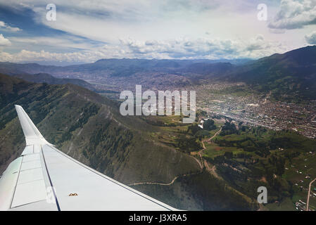 Cusco Stadt vom Flugzeug Fensteransicht, Flugzeugflügel unter Stadt in Berglandschaft Stockfoto