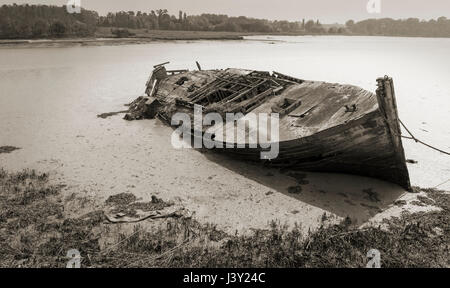 Verlassener und Fäulnis Holzboot haben in Schlamm bei Ebbe auf dem River Deben in Woodbridge Suffolk England versenkt. Stockfoto